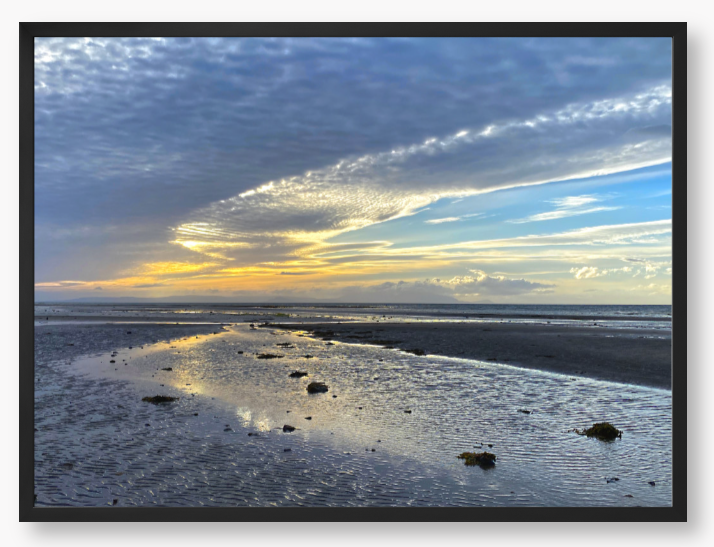 Framed Photo Of A Sunset over a beach with clouds and water reflections