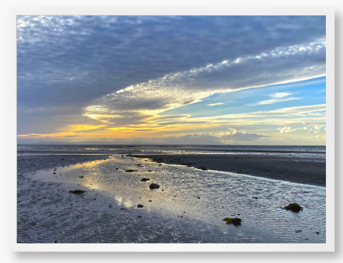 Framed Photo Of A Sunset over a beach with clouds and water reflections