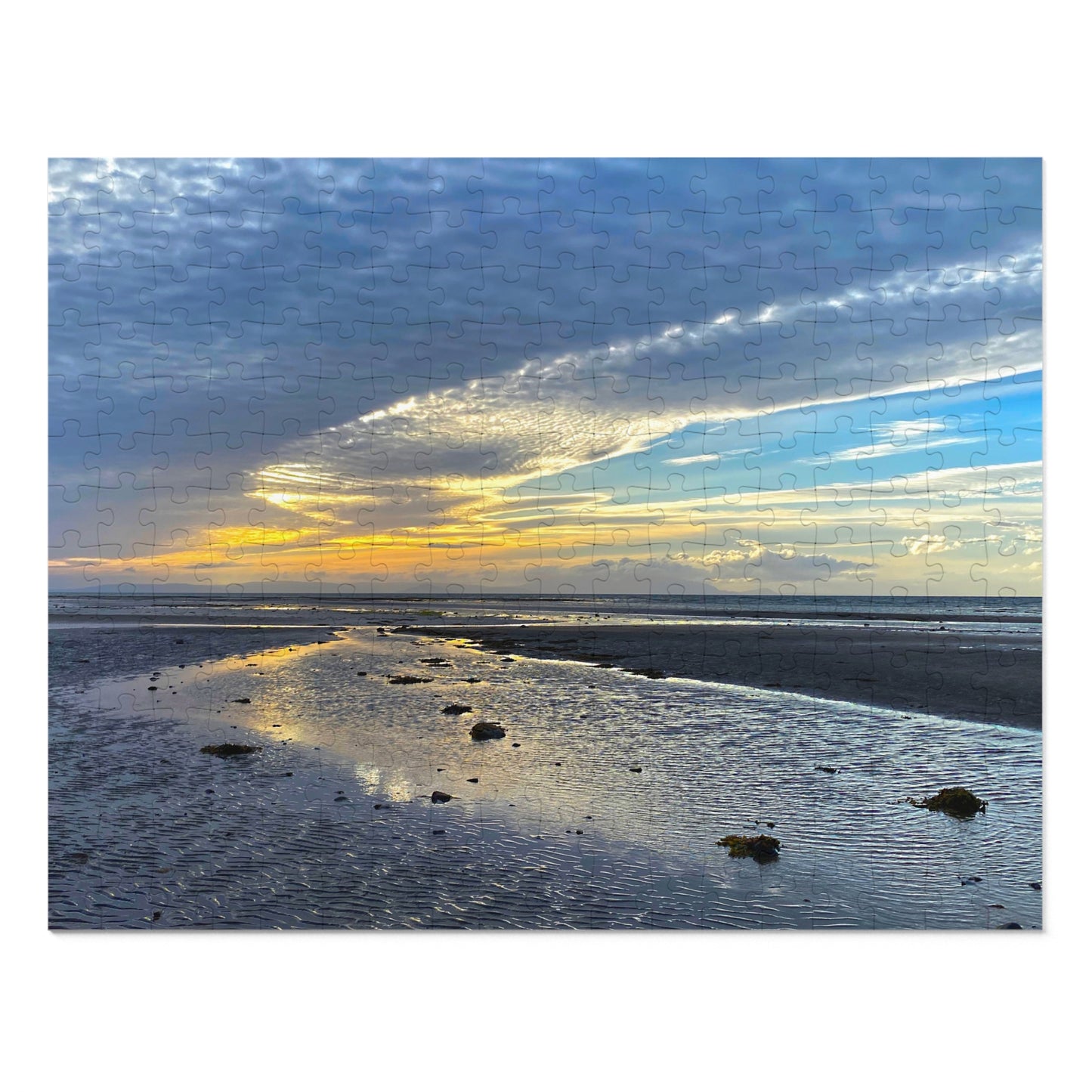 Beach scene with a sunset or sunrise over water and sky.