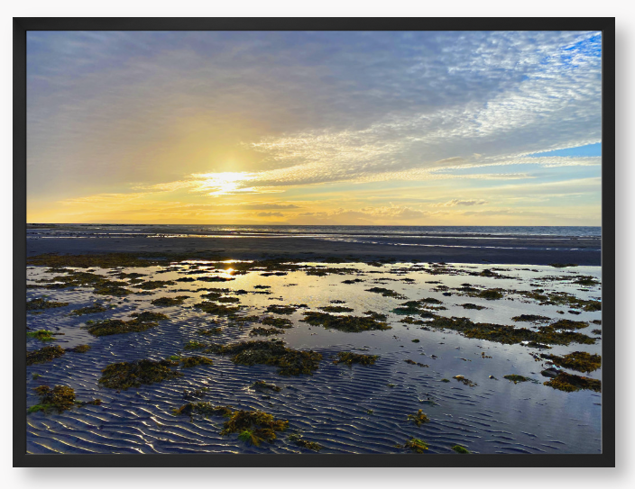 Framed Photo Of A Sunset over a coastal landscape with wet sand and low tide.