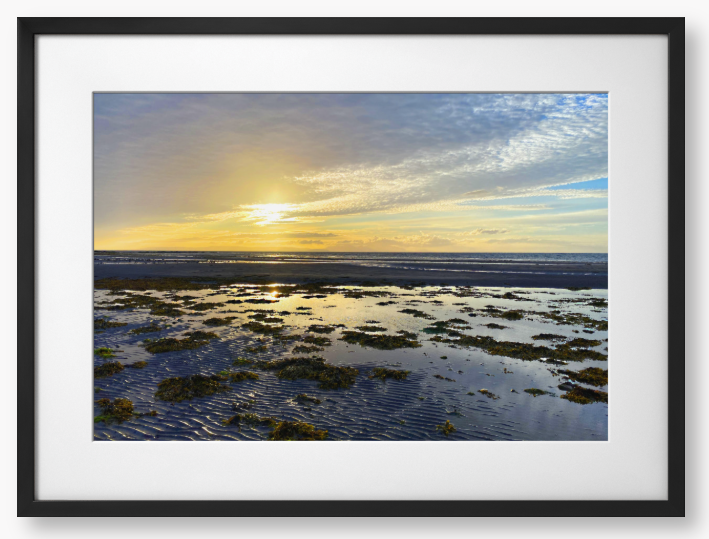 Framed Photo Of A Sunset over a coastal landscape with wet sand and low tide.