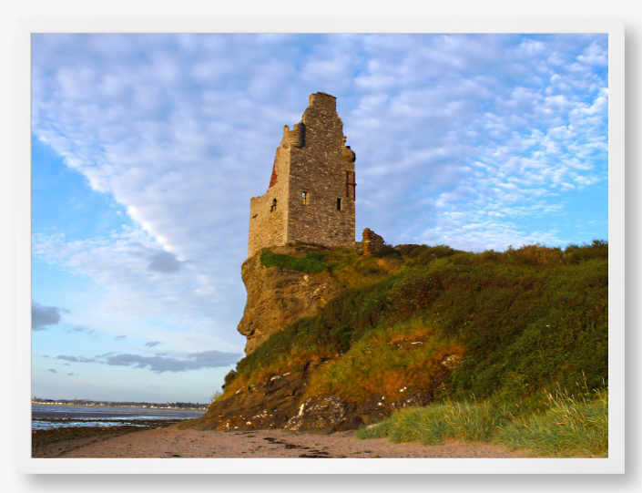 Framed Photo of Ruins of a tower on a cliff with a blue sky and clouds in the background
