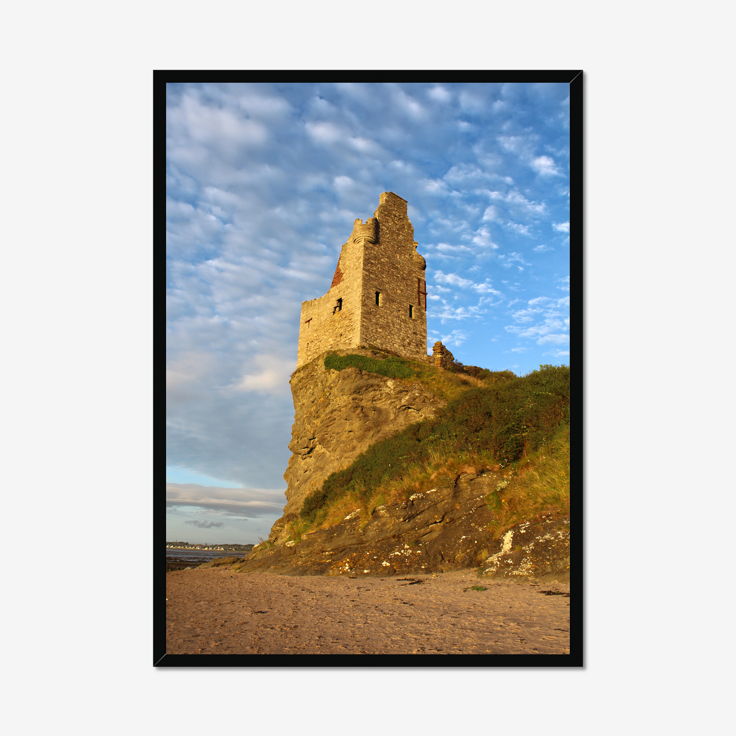 Framed photograph of a castle ruin on a cliff with a blue sky.