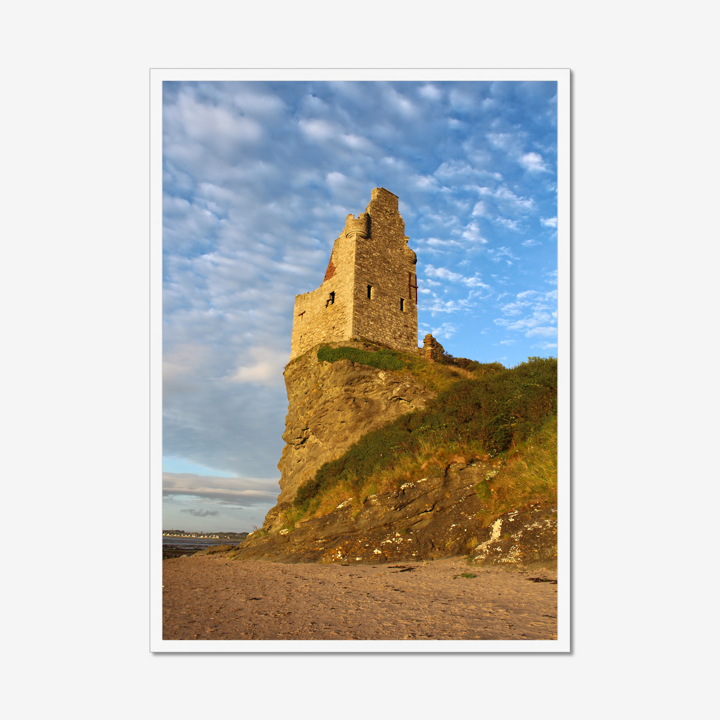 Ruins of a tower on a cliff with a blue sky and clouds
