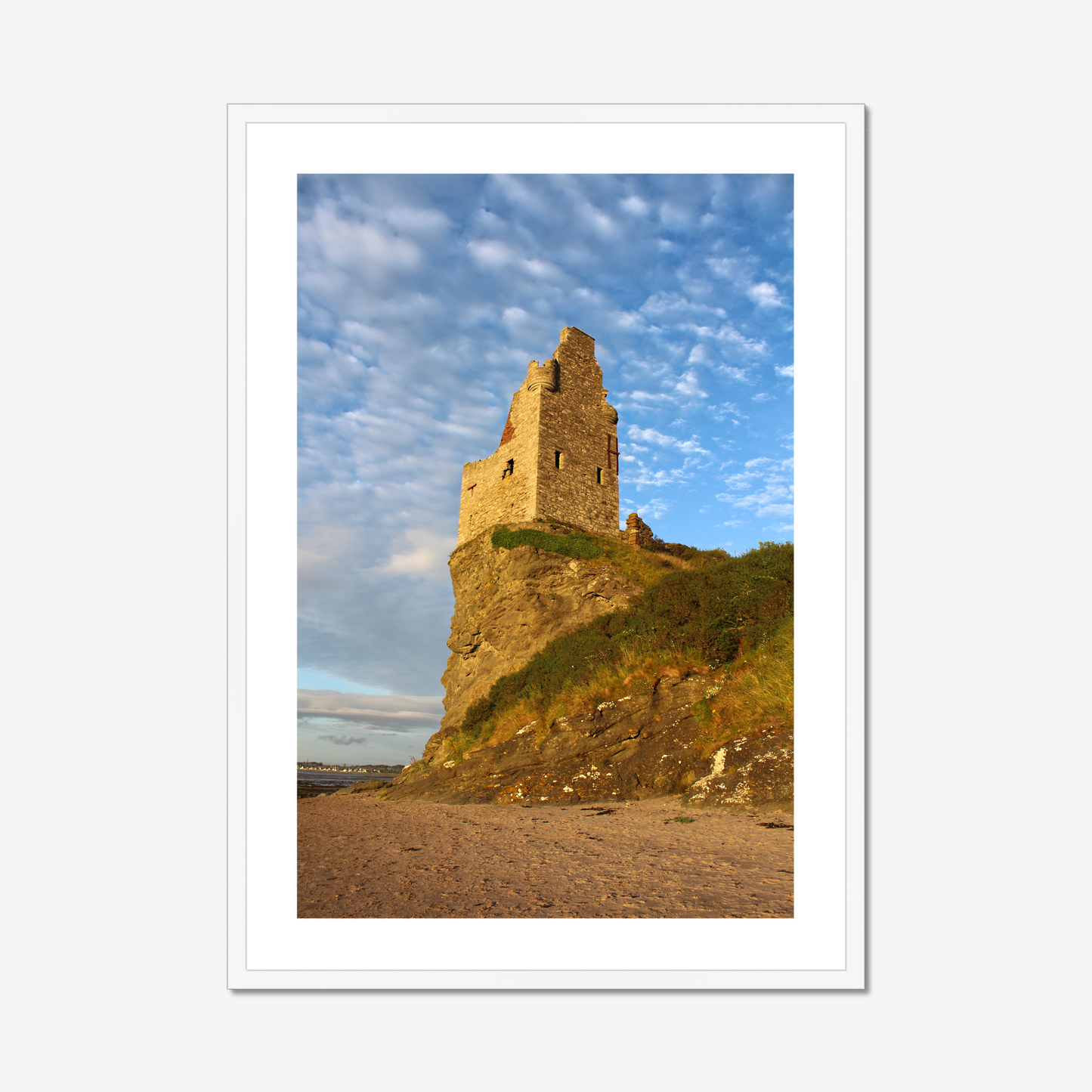 Ruined tower on a cliff with a blue sky and clouds