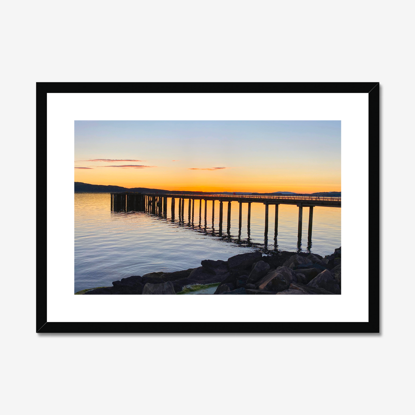 Framed artwork of a sunset over a dock with a black frame.
