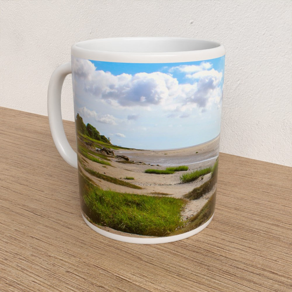 Mug with a scenic print of a beach and sky on a wooden surface