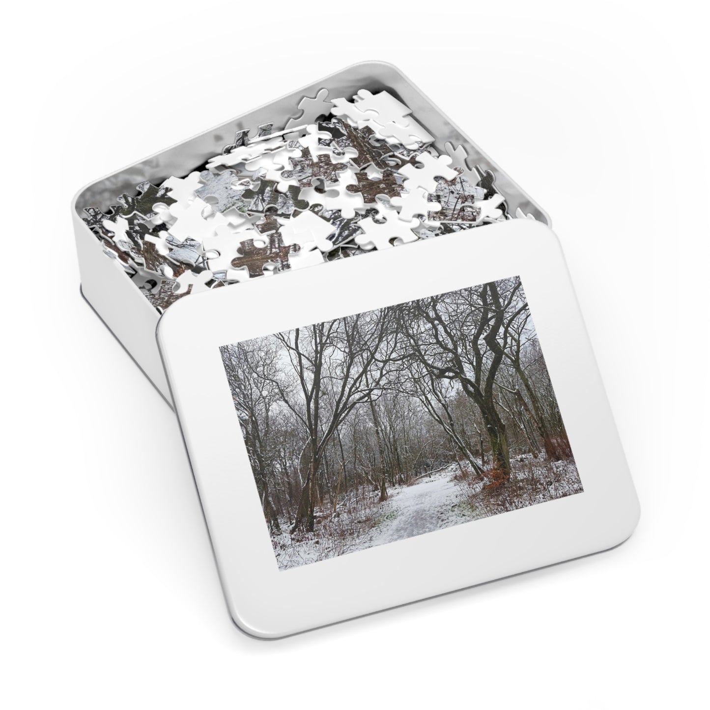 Jigsaw puzzle in a tin with a winter forest scene on the lid
