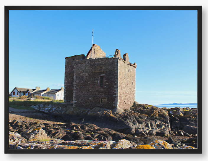 Framed Photo of a Stone castle on rocky terrain with a clear blue sky