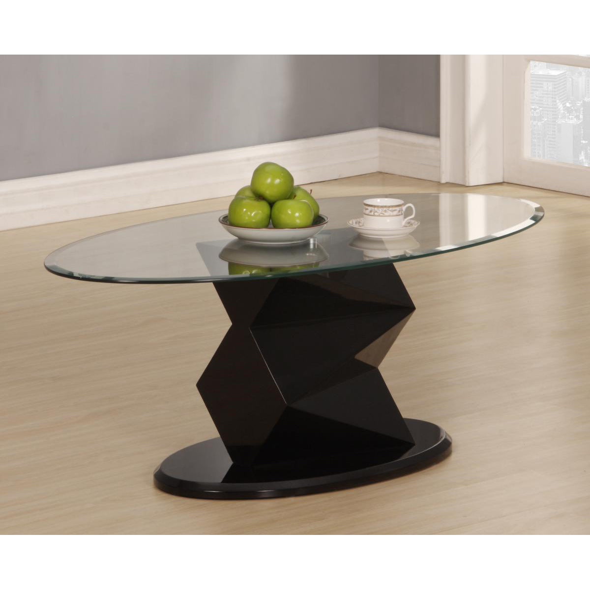 Glass coffee table with black geometric base on a wooden floor