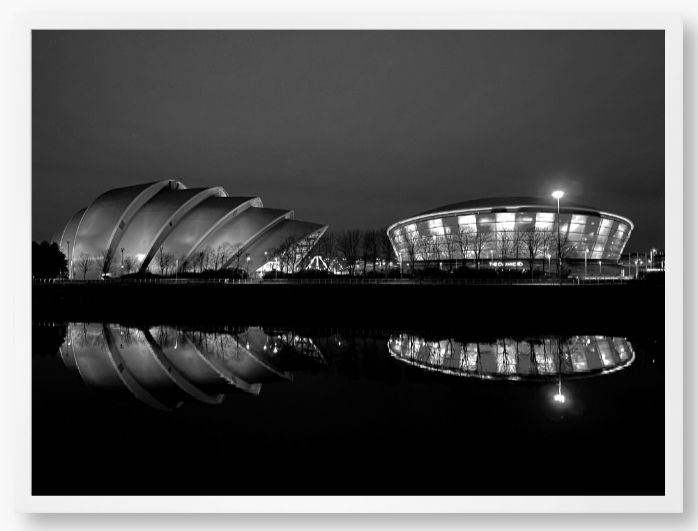 Black and White Framed Photo featuring the Glasgow SEC Armadillo and Hydro buildings lit up at night, reflected in the water of the Clyde.