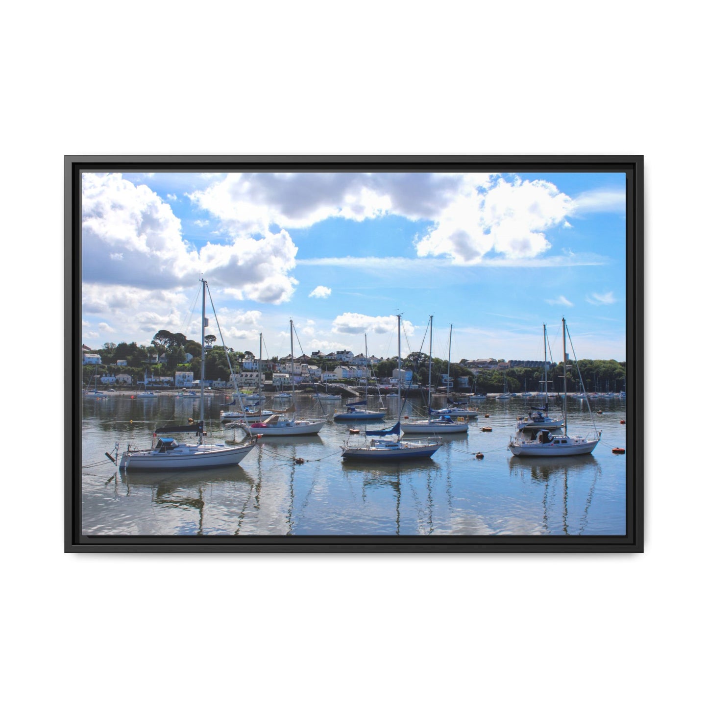 Framed photograph of a harbour with boats and a blue sky.