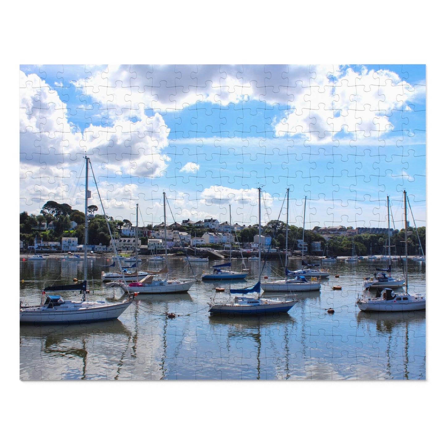 Harbour scene with boats docked under a blue sky with clouds.
