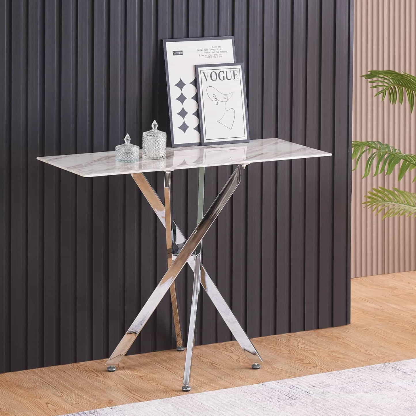 Small table with marble top and metal legs against a black paneled wall.