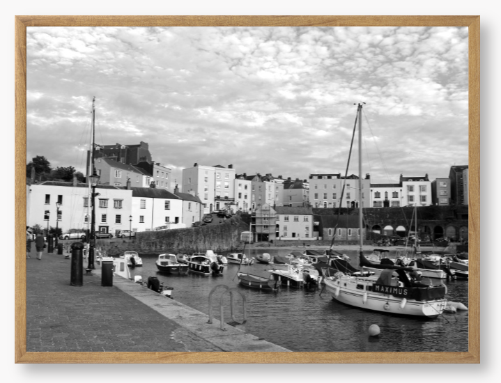 Black and white framed photo of a harbour scene with boats and buildings