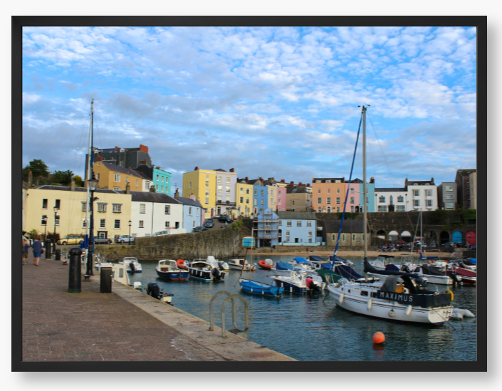 Framed Photo of a Harbour scene with colourful buildings and boats under a blue sky