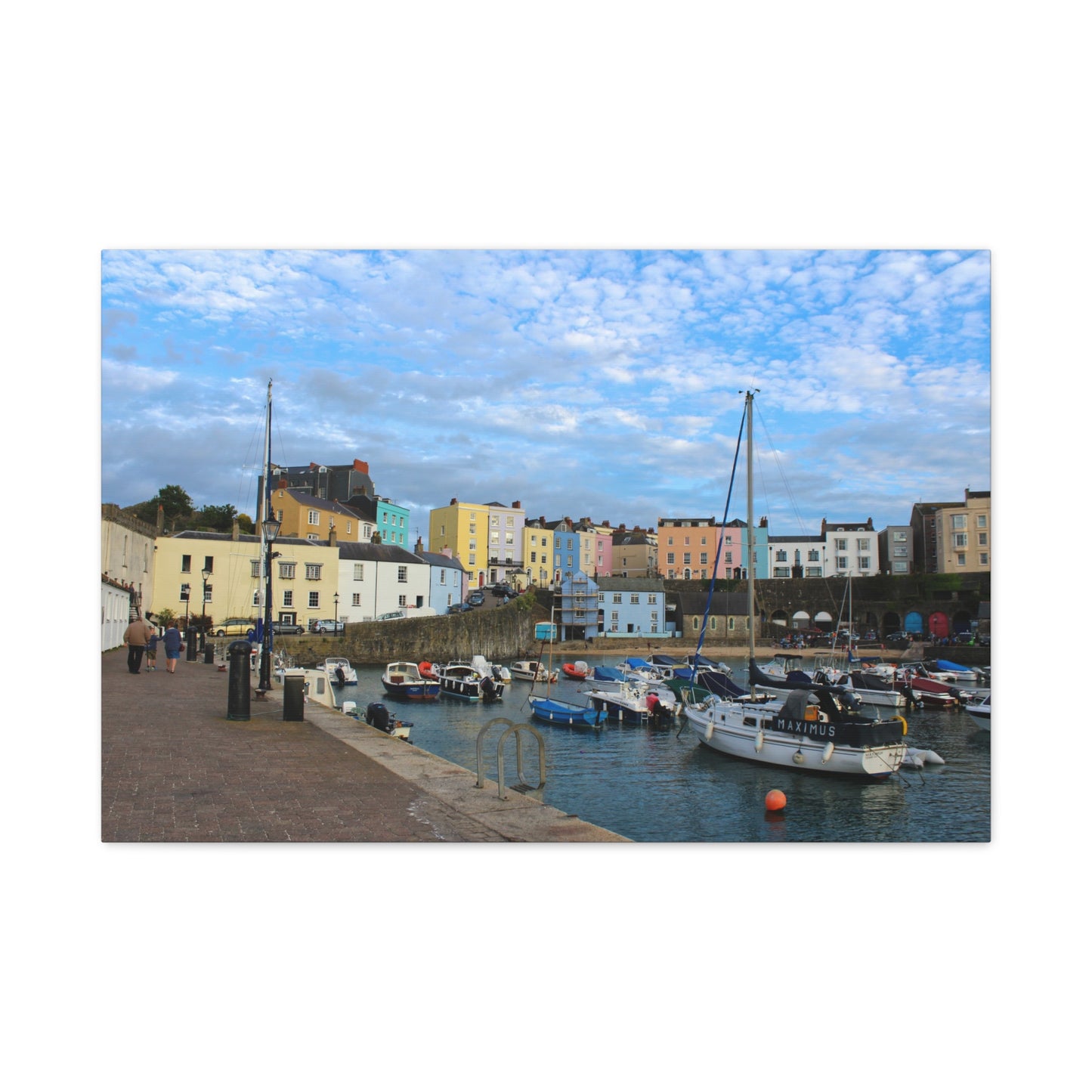 Harbour scene with colourful buildings and boats under a blue sky.