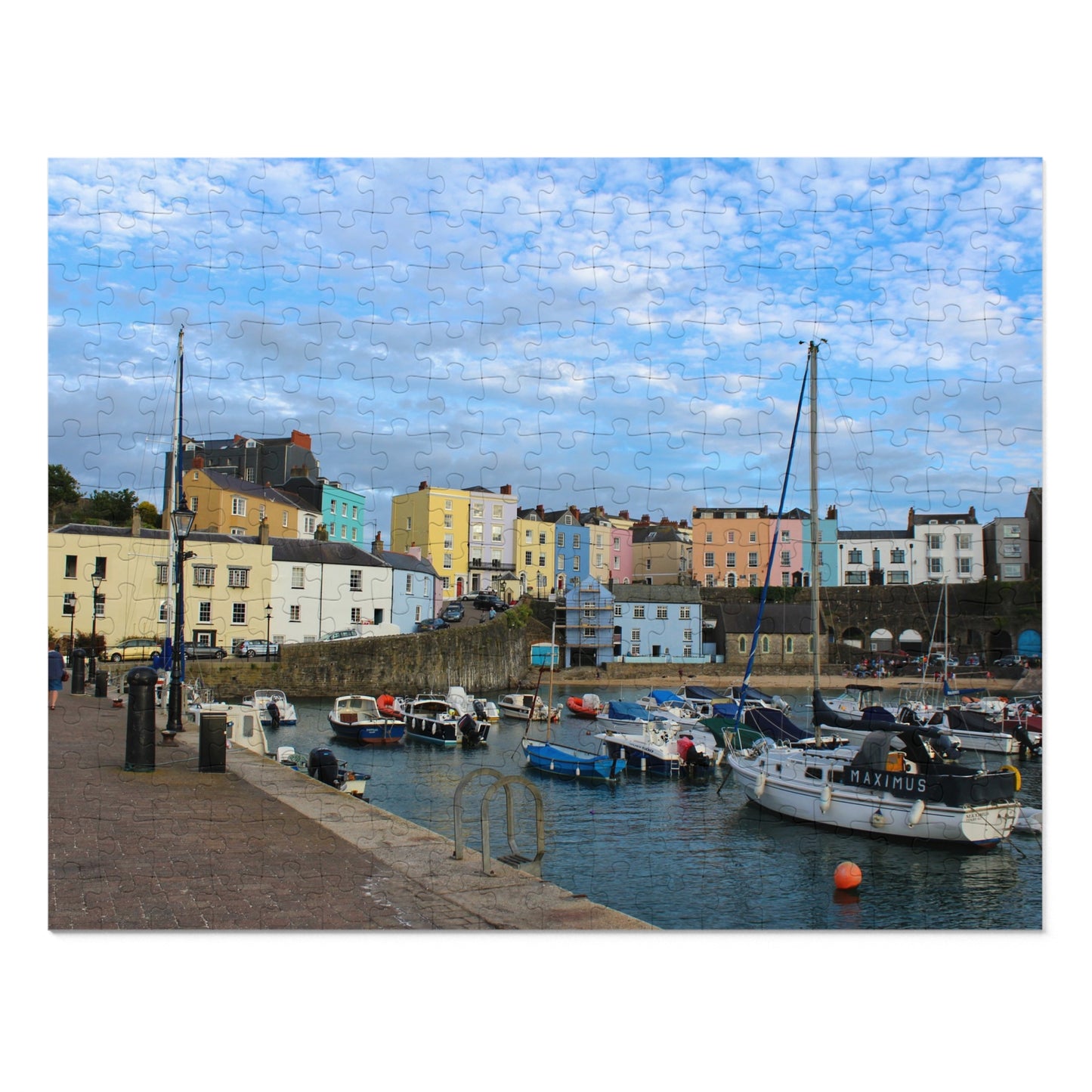 Harbour scene with colourful buildings and boats under a blue sky.