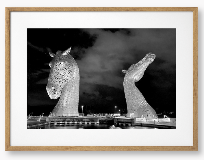 Black and White Framed Photo of the Kelpies horse sculptures in Falkirk, Scotland, illuminated at night.