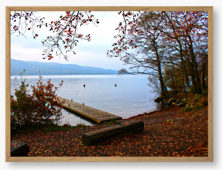 Framed Photo of a Autumn scene by a lake with a wooden jetty and trees with red leaves.
