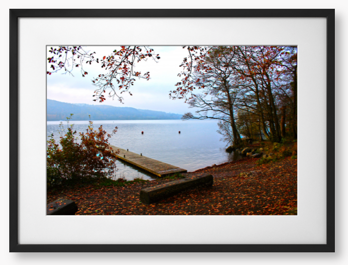 Framed Photo of a Autumn scene by a lake with a wooden jetty and trees with red leaves.