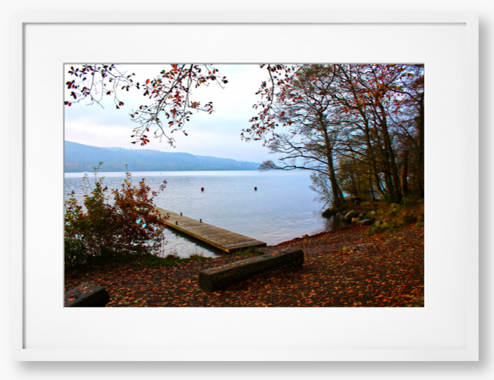 Framed Photo of a Autumn scene by a lake with a wooden jetty and trees with red leaves.