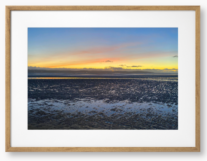 Framed Photo Of A Sunset over a calm body of water with a colorful sky.