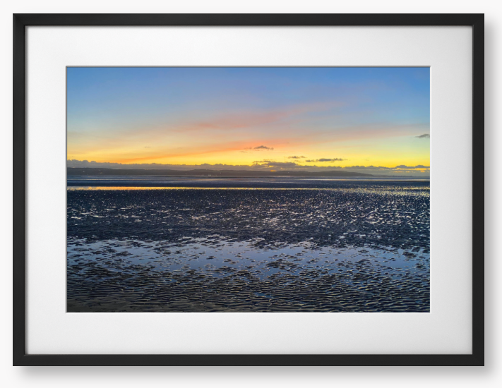 Framed Photo Of A Sunset over a calm body of water with a colorful sky.