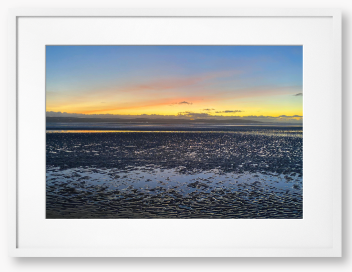 Framed Photo Of A Sunset over a calm body of water with a colorful sky.