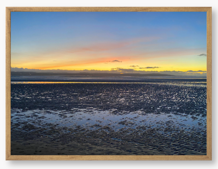 Framed Photo Of A Sunset over a calm body of water with a colorful sky.