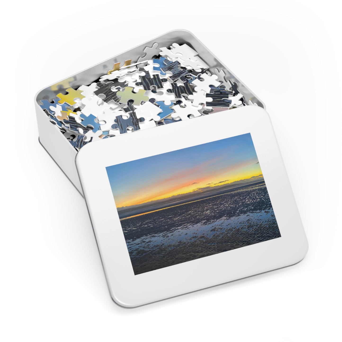 Jigsaw puzzle in a tin with a sunset over water image on the lid