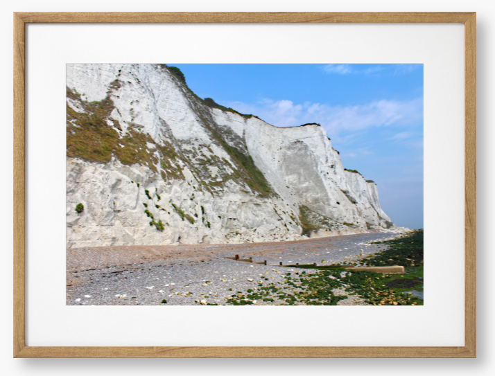 Framed Photo of White cliffs with a pebbly beach and blue sky