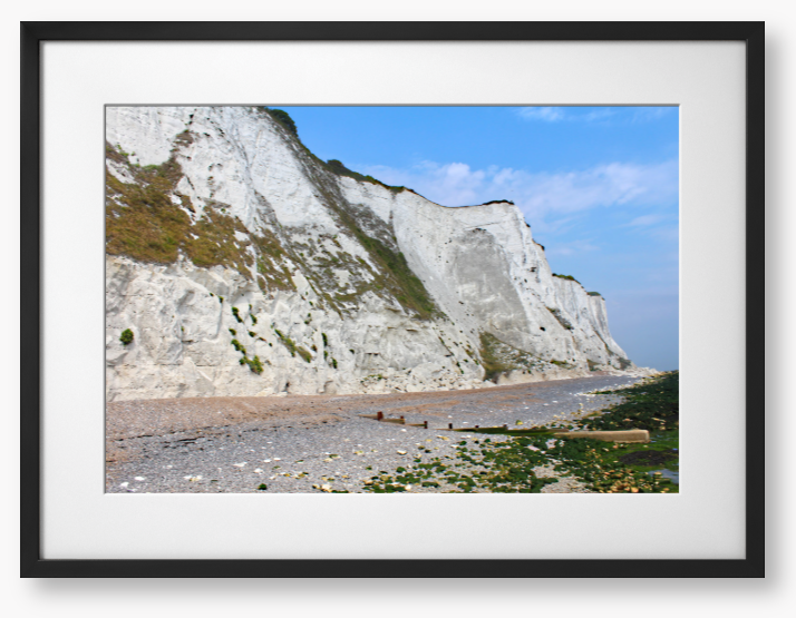 Framed Photo of White cliffs with a pebbly beach and blue sky
