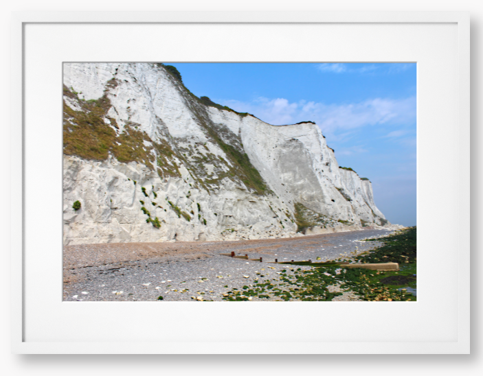Framed Photo of White cliffs with a pebbly beach and blue sky