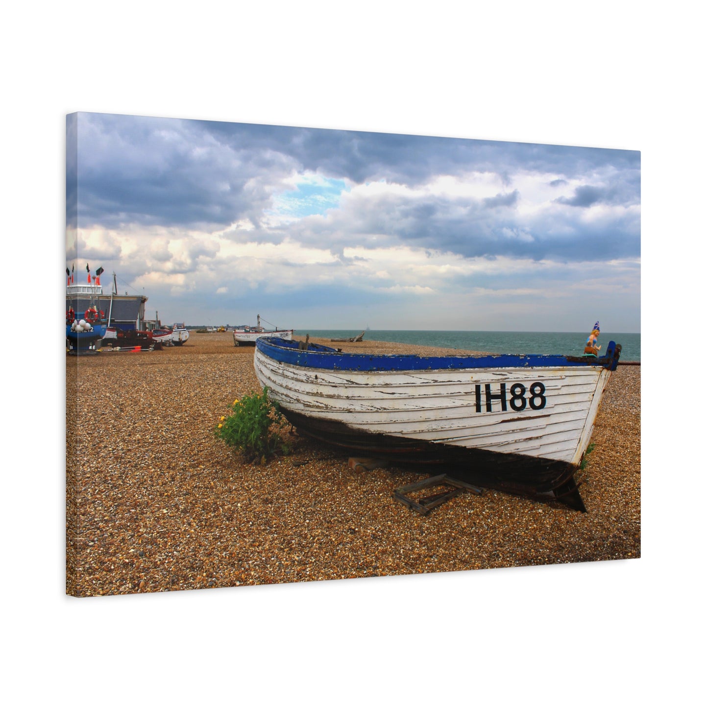 Boat on a pebbly beach with a cloudy sky