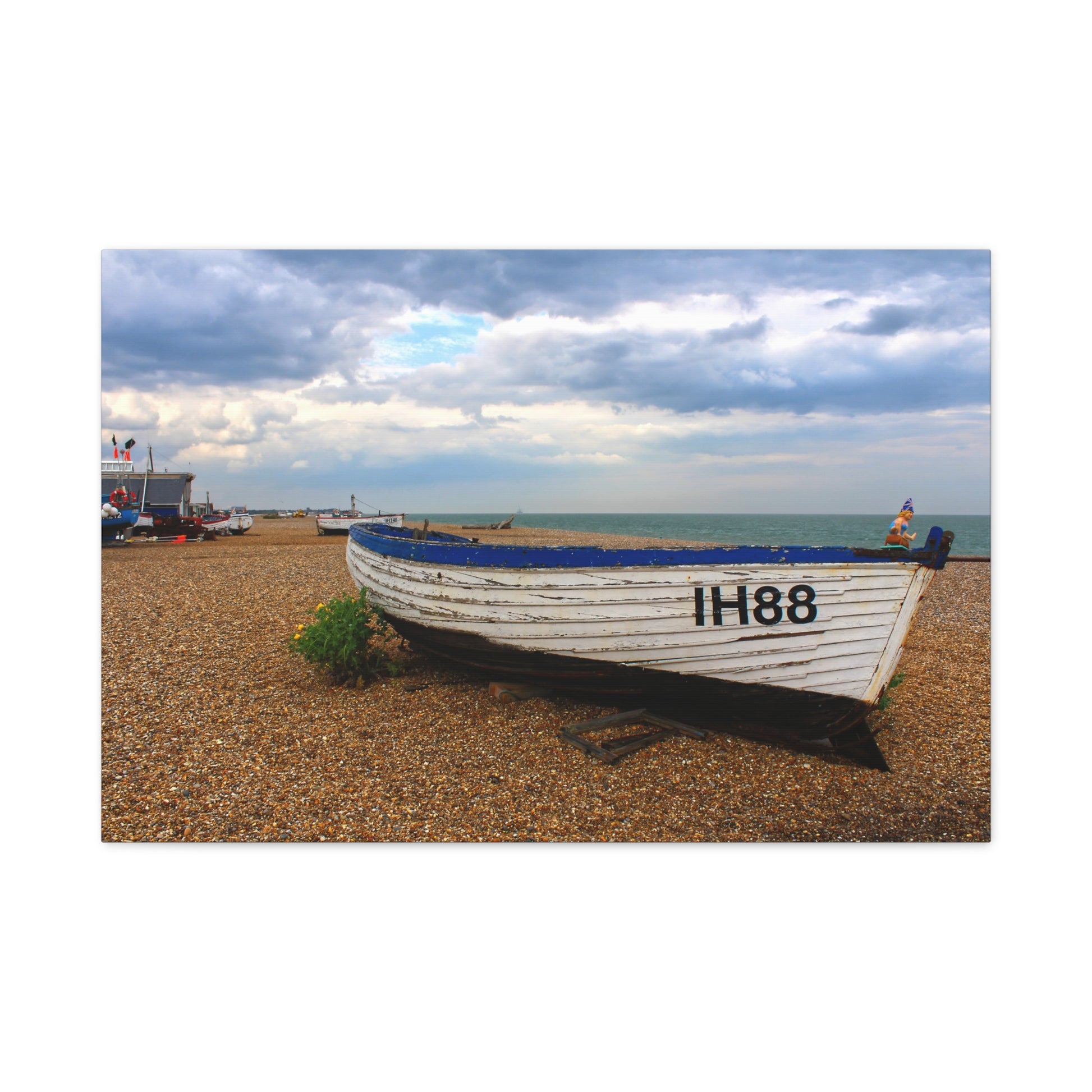 Boat on a pebble beach with a cloudy sky