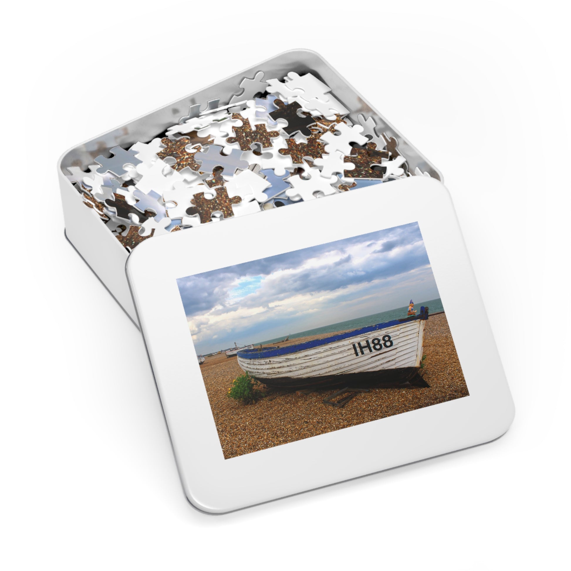 Jigsaw puzzle in a tin with a picture of a boat on a beach