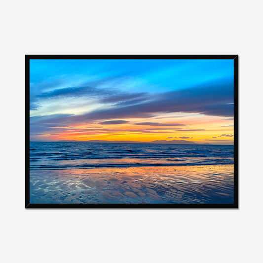 Framed artwork of a sunset over water with a black frame.