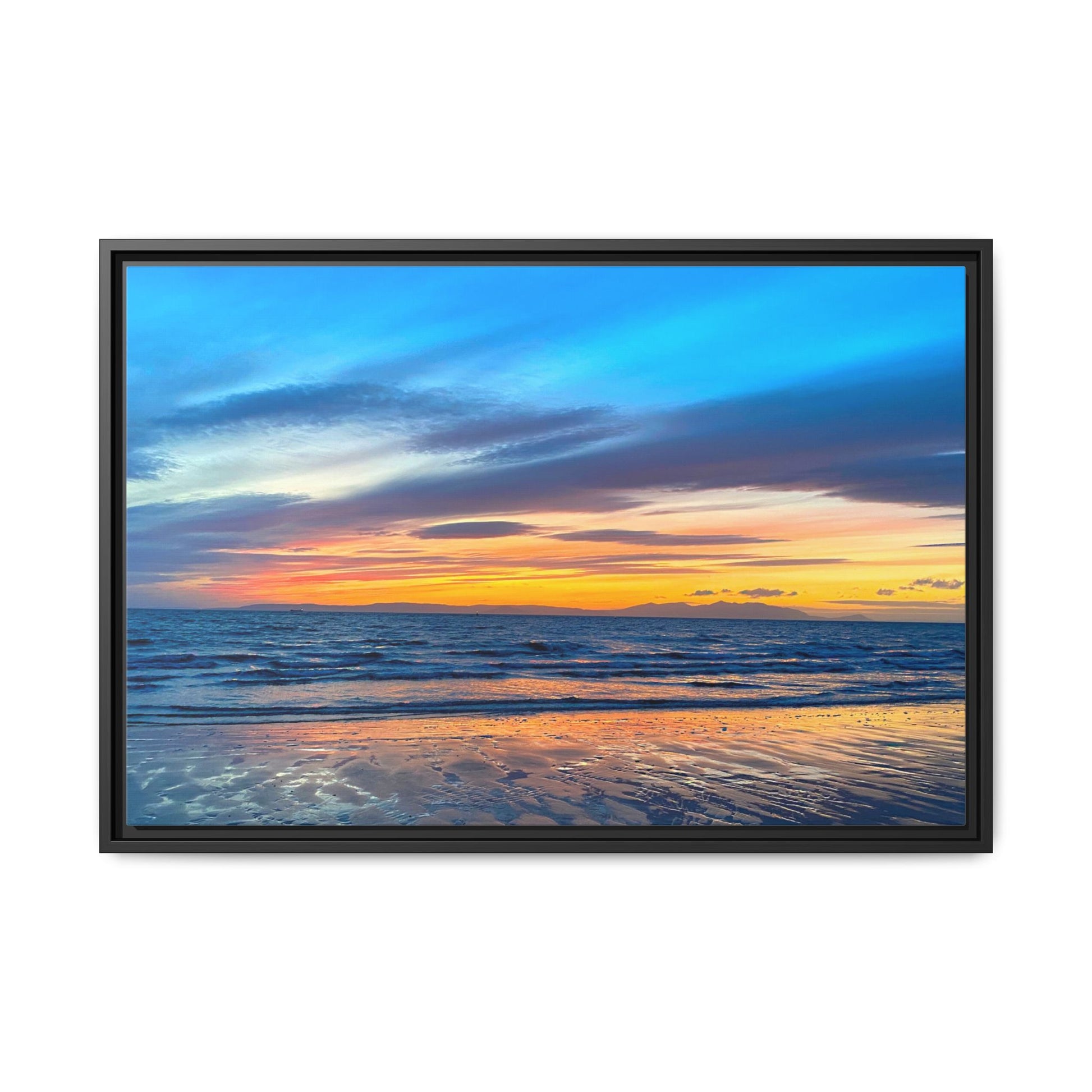 Framed artwork of a sunset over the ocean with a black frame.