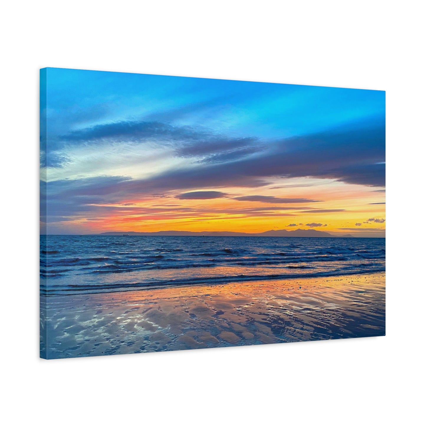 Canvas print of a sunset over the ocean with a beach.