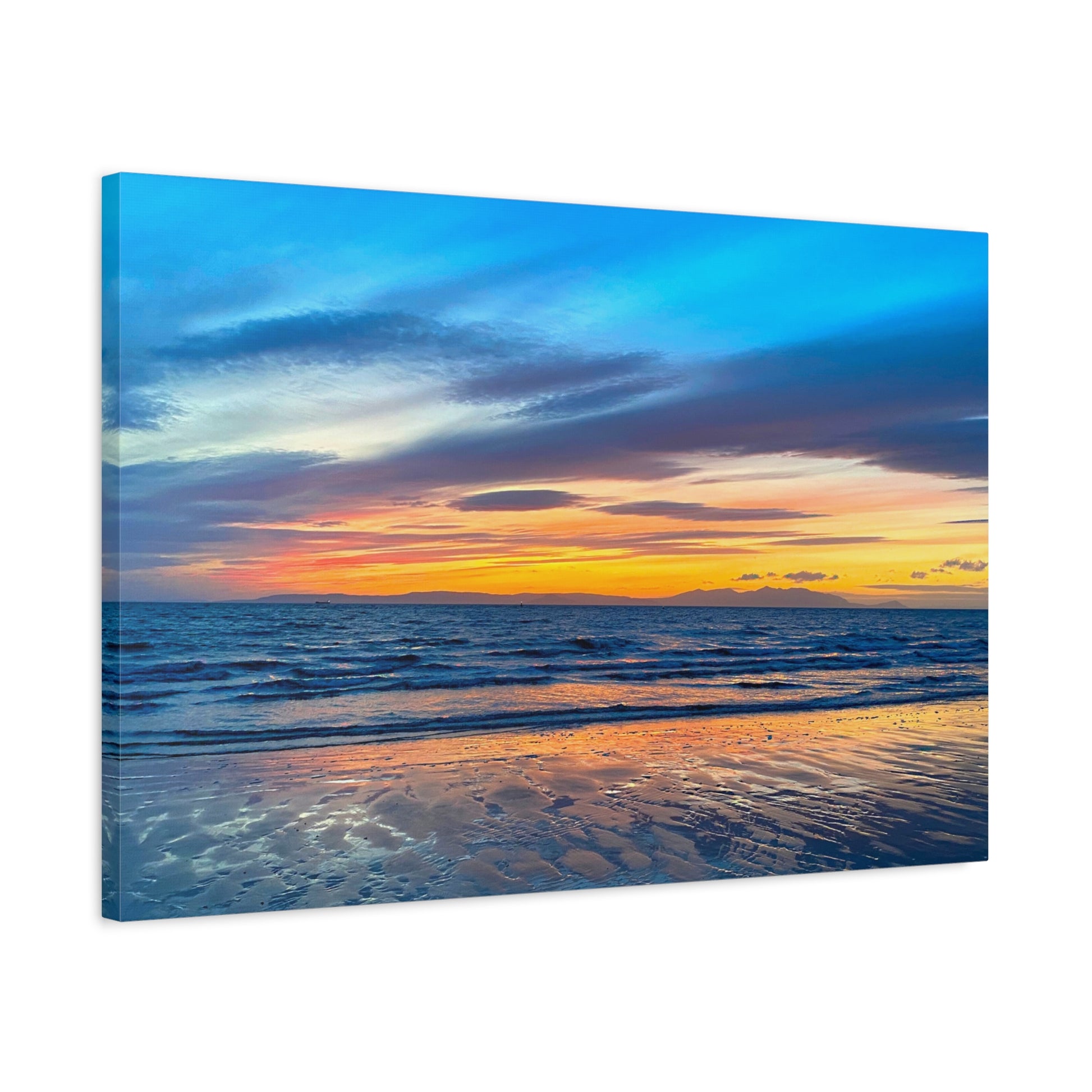 Canvas print of a sunset over the ocean with a beach.