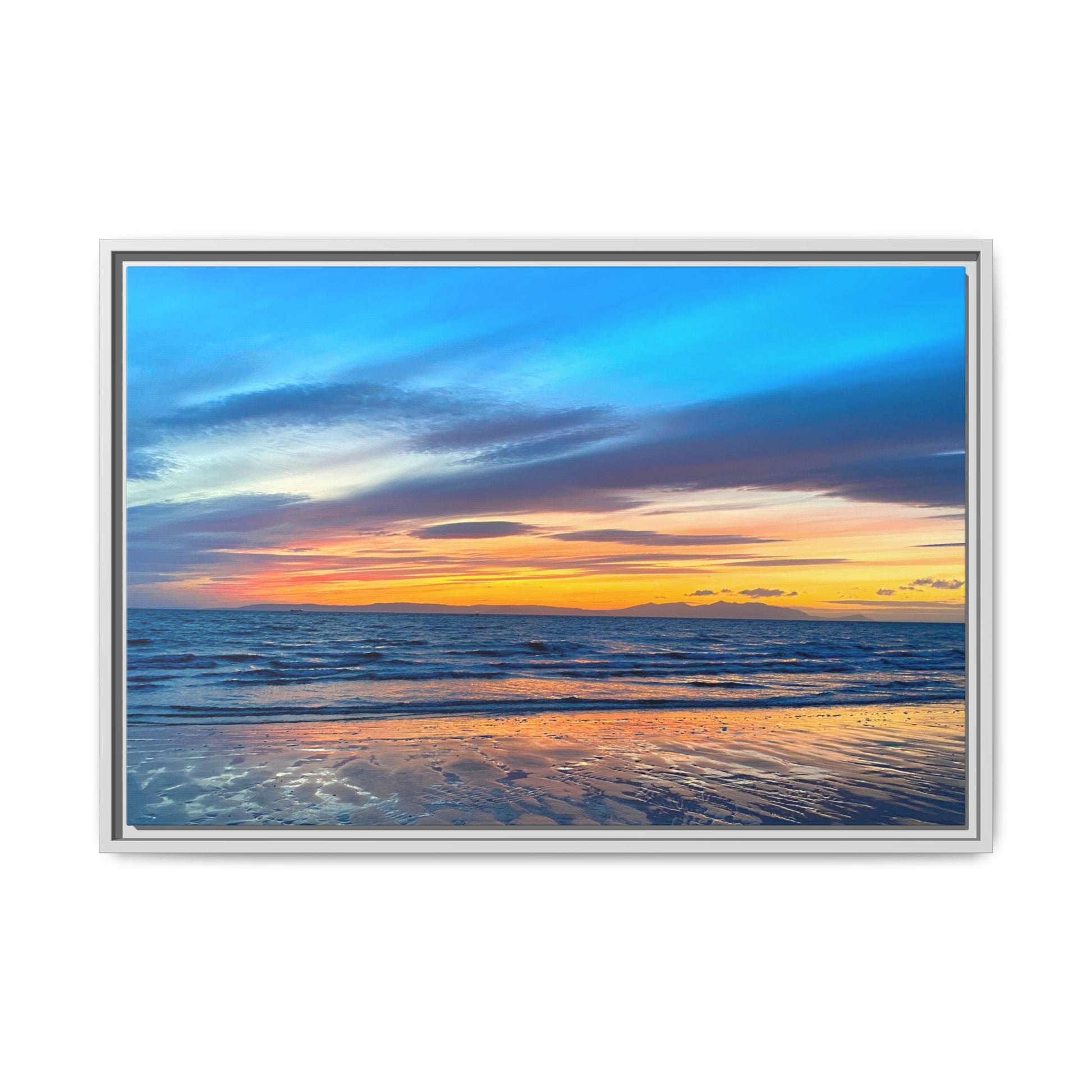 Framed artwork of a sunset over the ocean with a white frame.