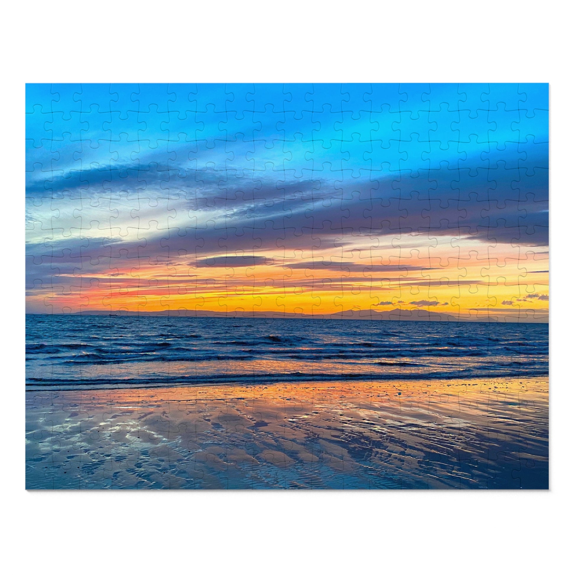 Sunset over the ocean with a blue cloudy sky