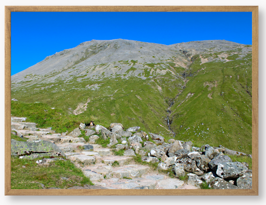 Framed Photo Of A Mountain landscape with a clear blue sky and a path leading to the peak.