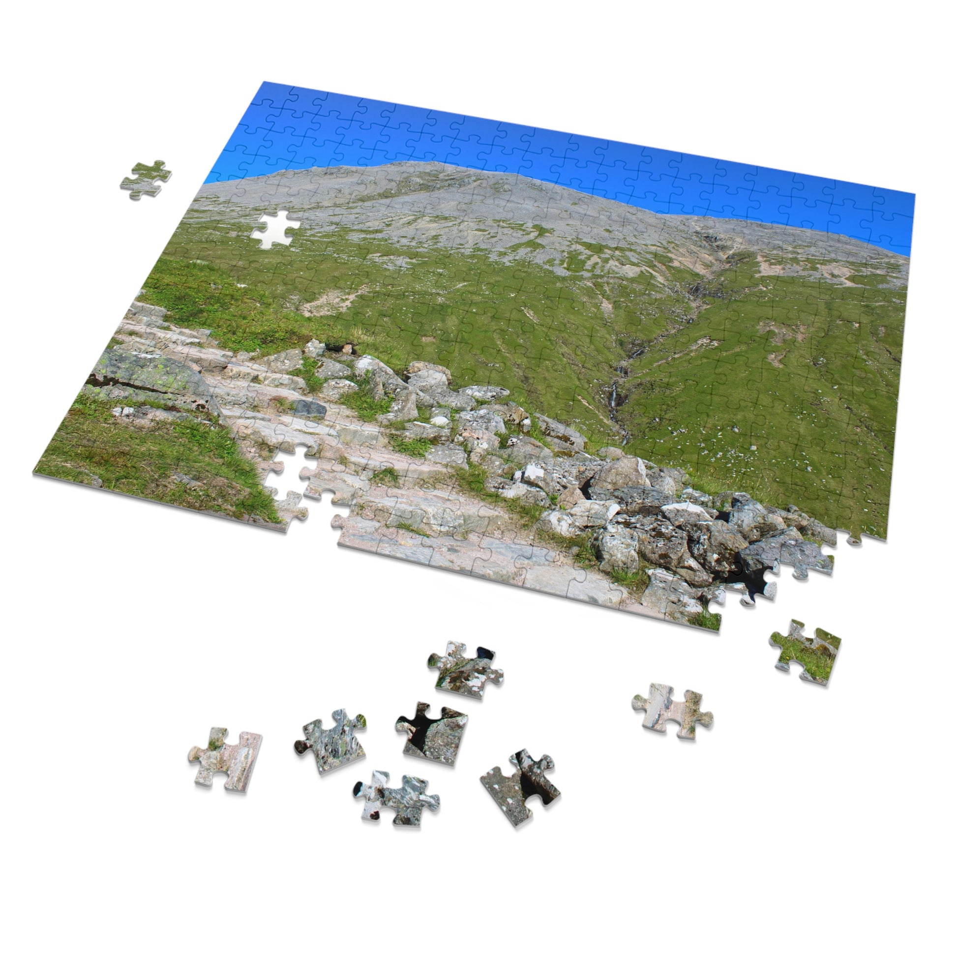 Jigsaw puzzle of a mountain landscape with completed pieces on a white background
