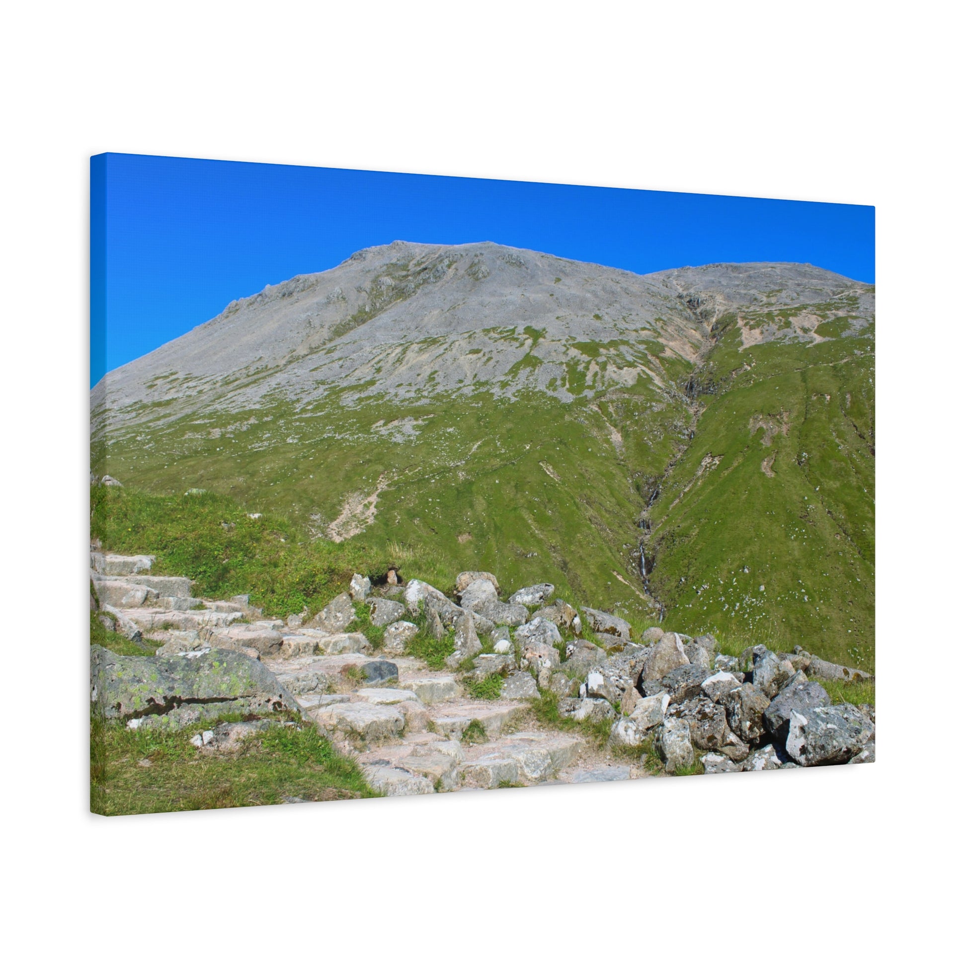 Staircase leading up a grassy mountain with a clear blue sky