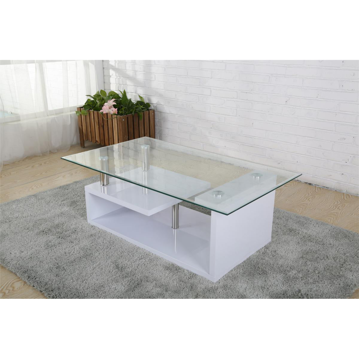 Glass coffee table with white high gloss base in a room with a rug and plant