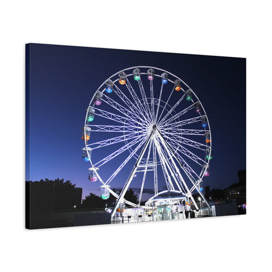 Ferris wheel illuminated at night with a clear sky