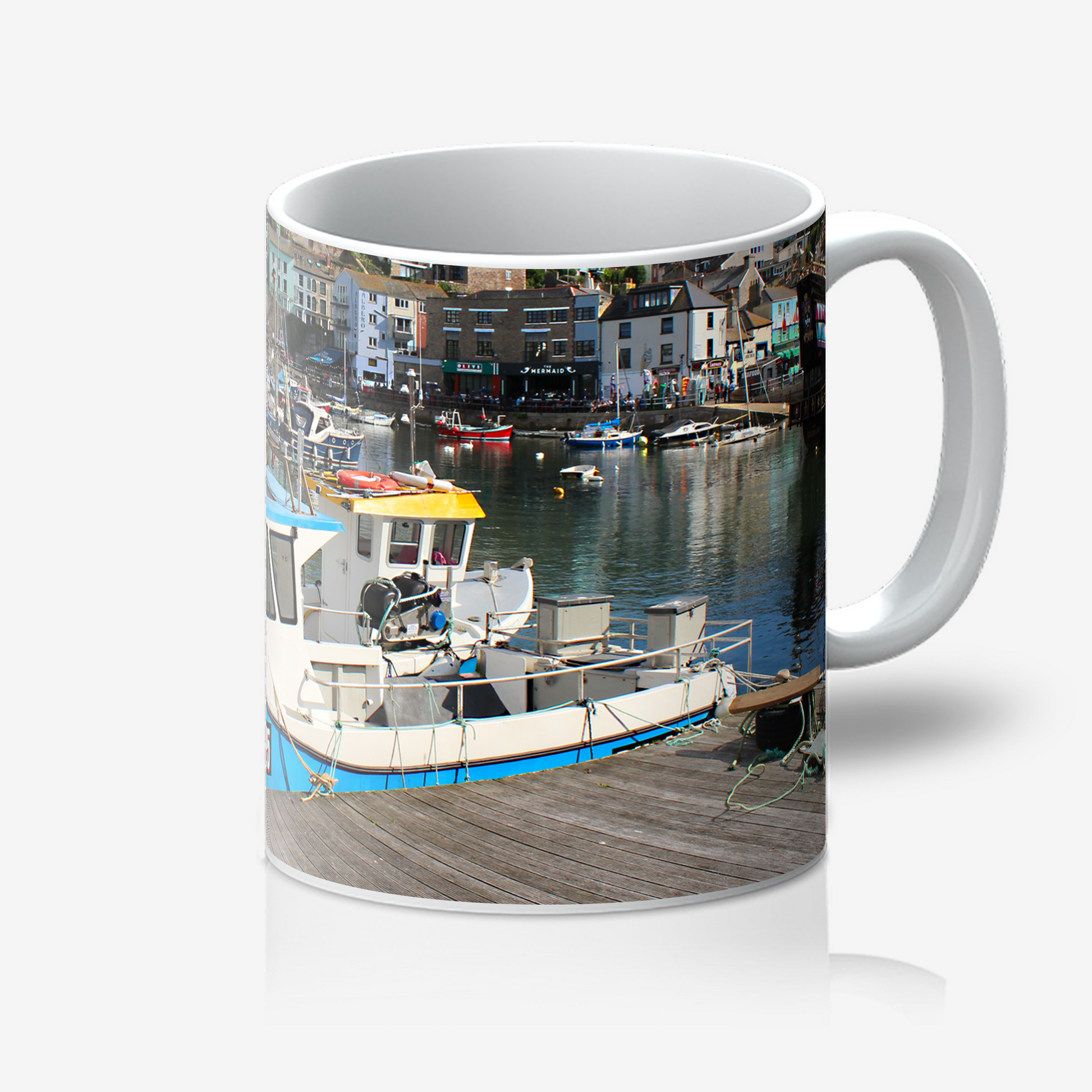 Mug with a scenic design of boats and buildings on a white background