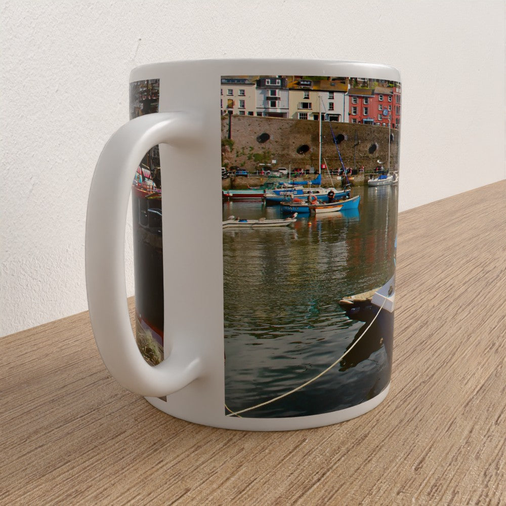 Mug with a scenic design of a harbor on a wooden surface